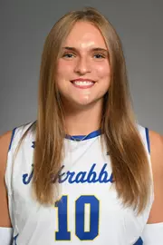 A volleyball player in white poses for her headshot