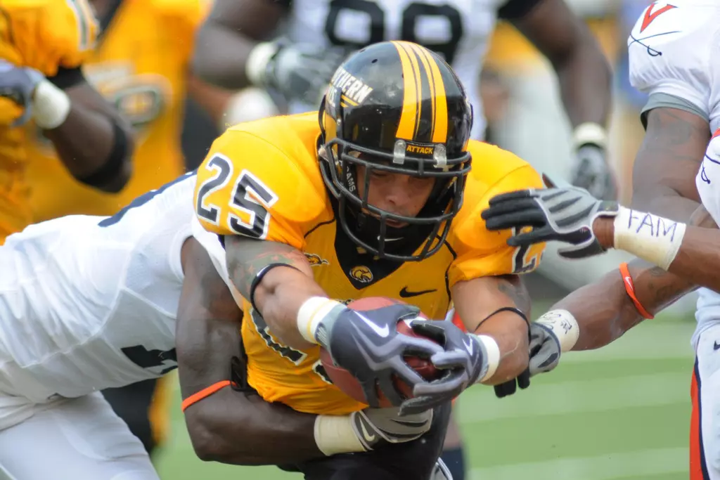Southern Mississippi running back Damion Fletcher (25) leaps into the end zone while in the grasp of Virginia cornerback Ras-l Dowling. behind, in the second quarter of an NCAA football game in Hattiesburg, Miss., Saturday, Sept. 19, 2009.