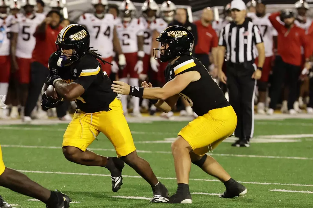 Southern Mississippi Golden Eagles quarterback Landry Lyddy (18) hands the ball off to Southern Mississippi Golden Eagles running back Steven Robinson (14) in a NCAA Football game between Southern Miss Golden Eagles and Arkansas State Red Wolves at Carlisle-Faulkner Field at Renasant Stadium. October 17, 2026 (Joe Harper/bgnphoto.com)