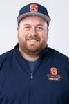 Syracuse field hockey assistant coach Sam Brown head shot. He's wearing a blue pullover with Syracuse University branding and a blue hat all on a white background.