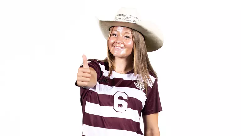Bailey Cate flashes a Gig 'em and dons a sharp cowboy hat.