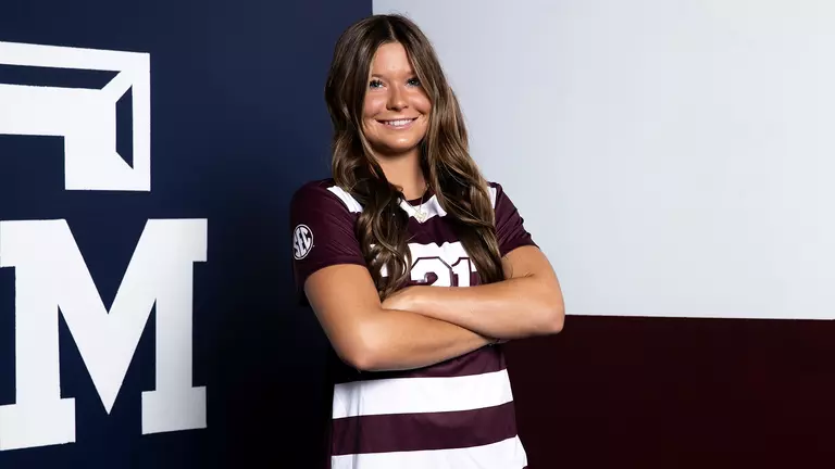 Holly Storer poses in front of a Texas A&M themed Lone Star flag during her media day portrait shoot.