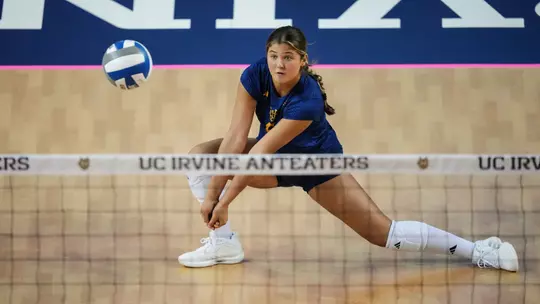 Whitney Wallace digs the ball in an NCAA women's volleyball match.