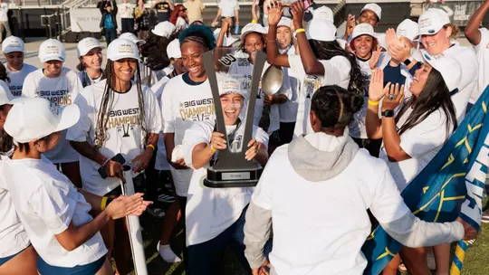 UC Irvine women's track & field team celebrates with the Big West Championship trophy