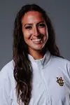 Women's volleyball assistant coach Tara Eaton poses for a head shot in a white quarter zip with the UCI stacked logo