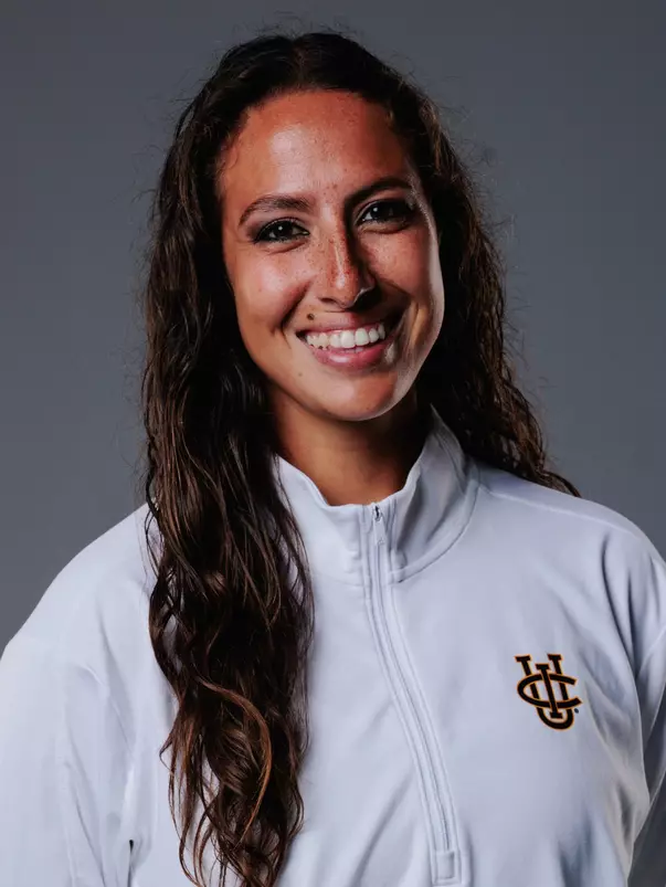 Women's volleyball assistant coach Tara Eaton poses for a head shot in a white quarter zip with the UCI stacked logo