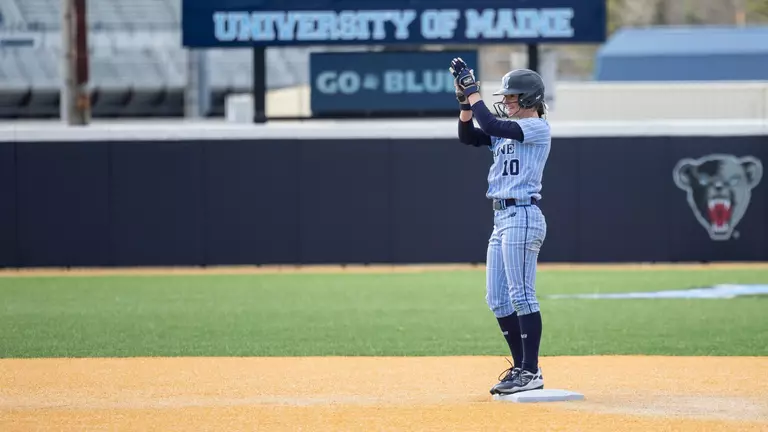 Keira Inman stands on second base, clapping.