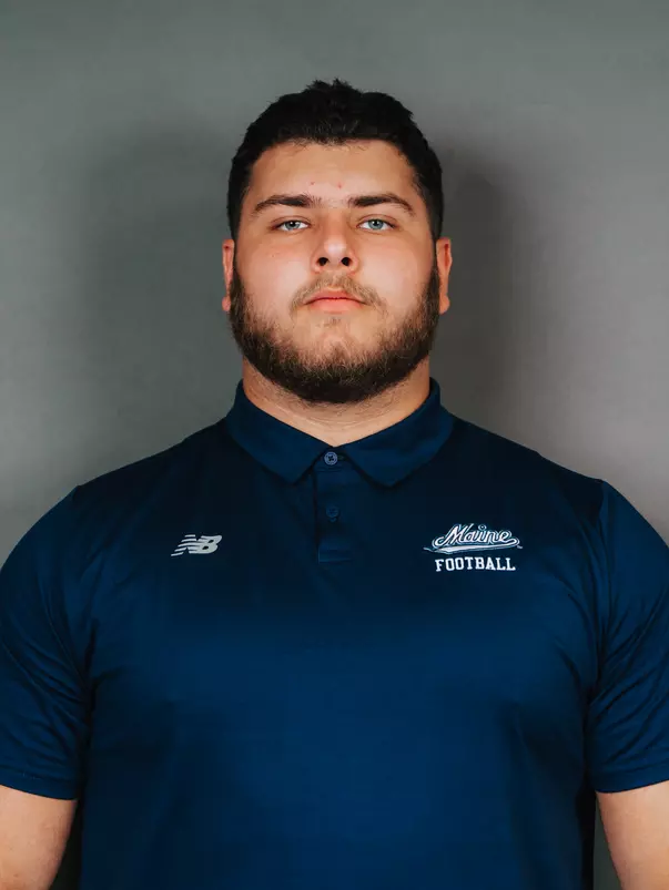 2026 Maine football roster head shot. Blue polo with Maine script.