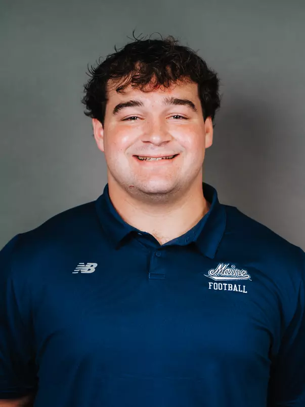 2026 Maine football roster head shot. Blue polo with Maine script.