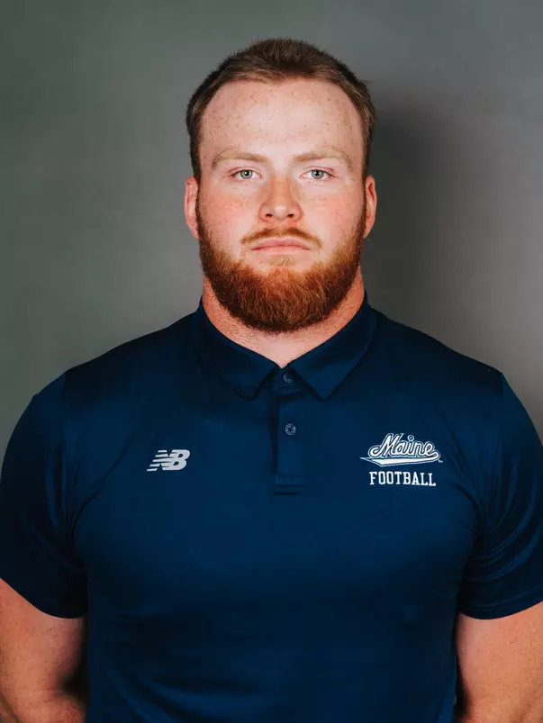 2026 Maine football roster head shot. Blue polo with Maine script.