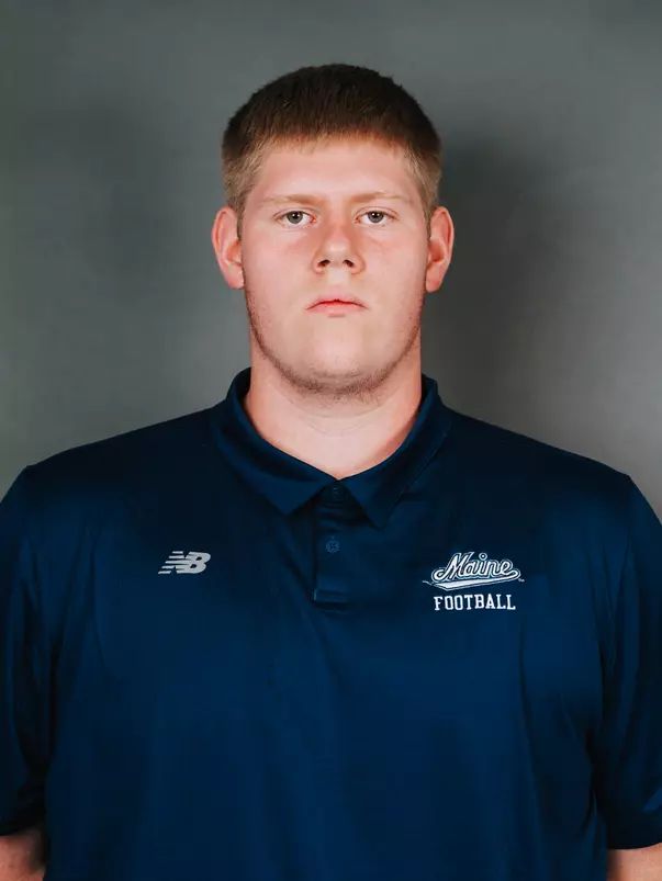 2026 Maine football roster head shot. Blue polo with Maine script.