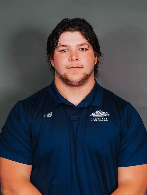 2026 Maine football roster head shot. Blue polo with Maine script.