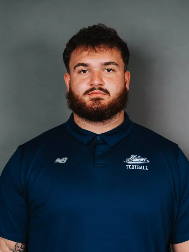 2026 Maine football roster head shot. Blue polo with Maine script.