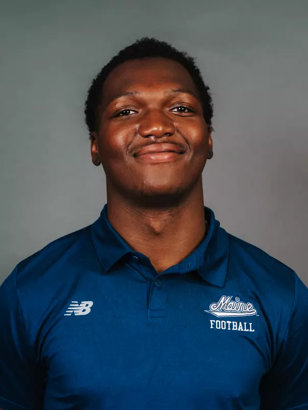 2026 Maine football roster head shot. Blue polo with Maine script.