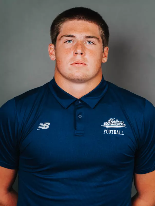 2026 Maine football roster head shot. Blue polo with Maine script.