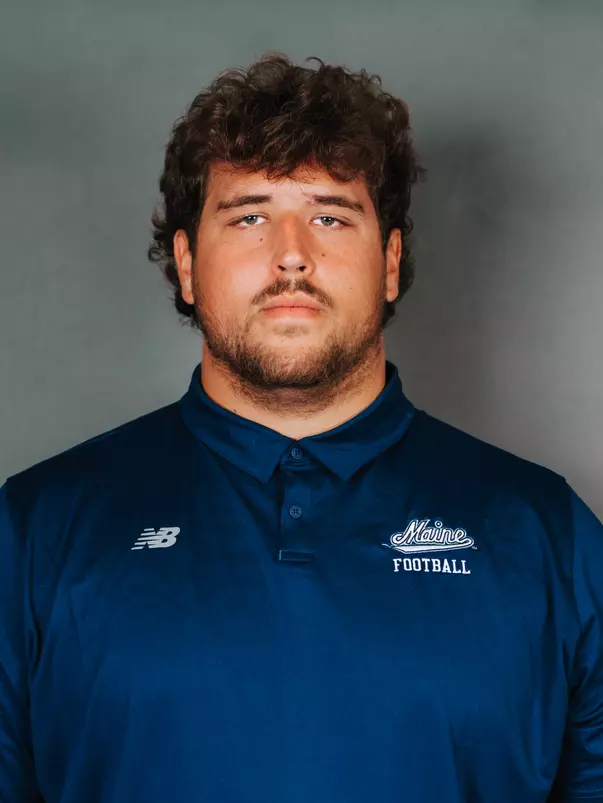 2026 Maine football roster head shot. Blue polo with Maine script.