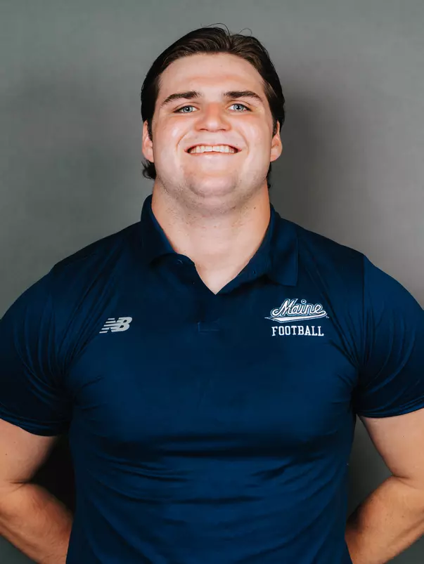 2026 Maine football roster head shot. Blue polo with Maine script.