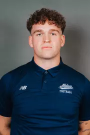 2026 Maine football roster head shot. Blue polo with Maine script.