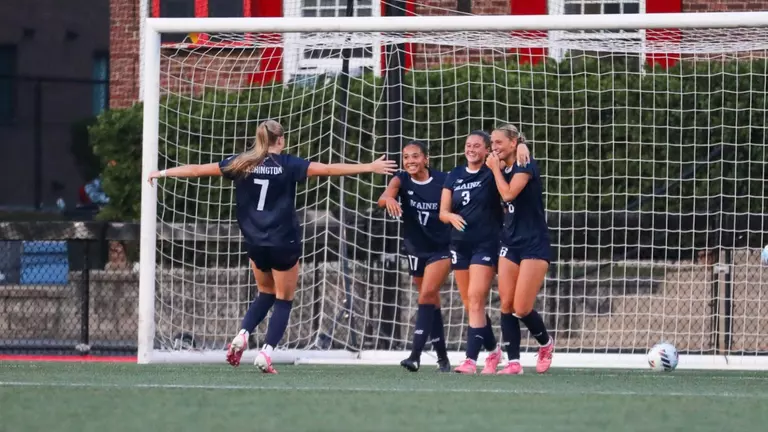 Maine women's soccer celebrates a goal.