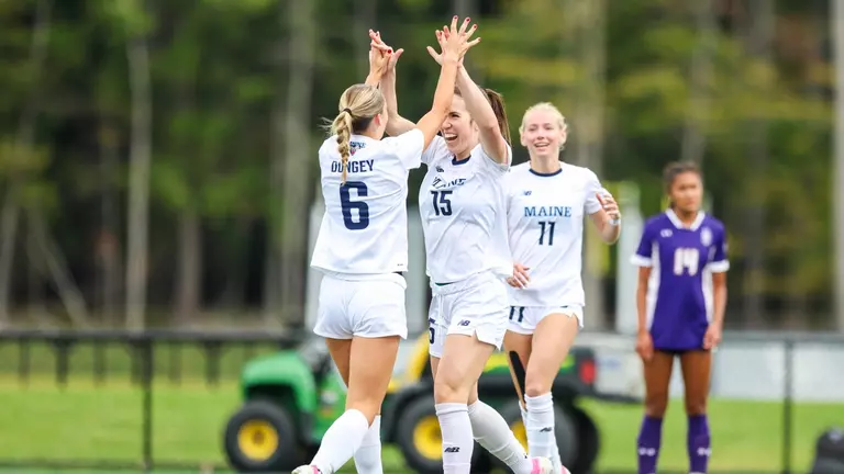 Maine women's soccer celebrates a goal.