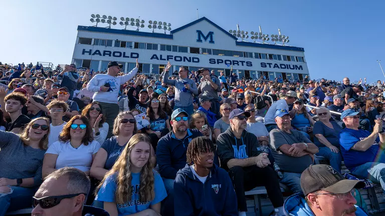 Two people do a high-five at Alfond Stadium