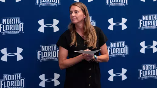 Assistant AD for Student-Athlete Center for Excellence Tara Sunquist holding a list of graduates at summer graduation ceremony