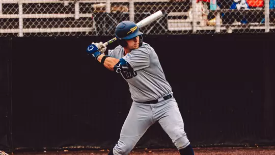 Jacob Payne swinging a bat in a gray uniform