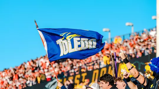 Fans cheer at the Glass Bowl and wave a Toledo flag