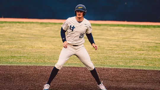 Cole Cahill taking a lead in a white uniform