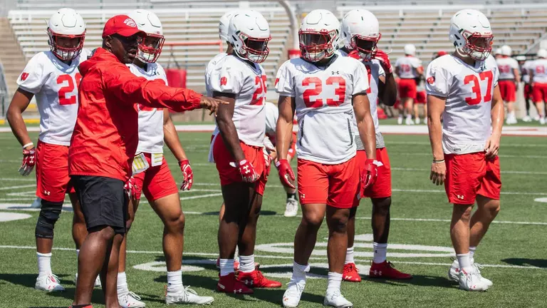 Football coach John Settle at practice coaching Jonathan Taylor (23) and Badgers