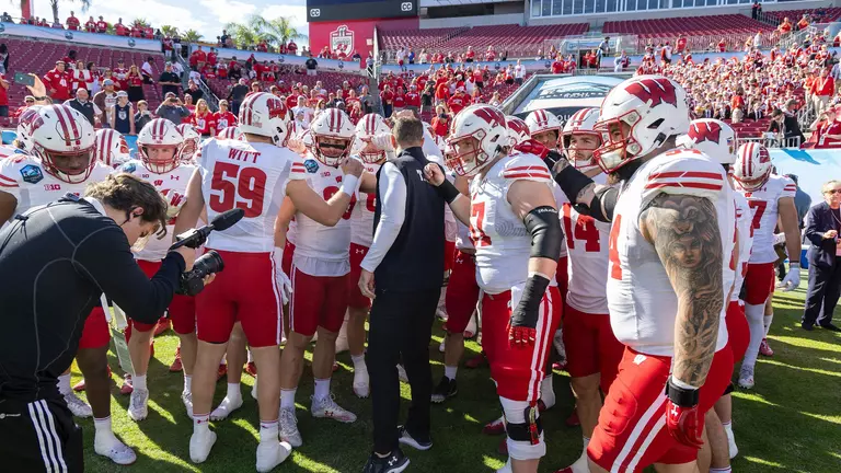 Wisconsin football head coach Luke Fickell in pre-game huddle with team prior to kickoff of 2024 ReliaQuest Bowl versus LSU at Raymond James Stadium in Tampa, Florida on Monday, January 1, 2024.