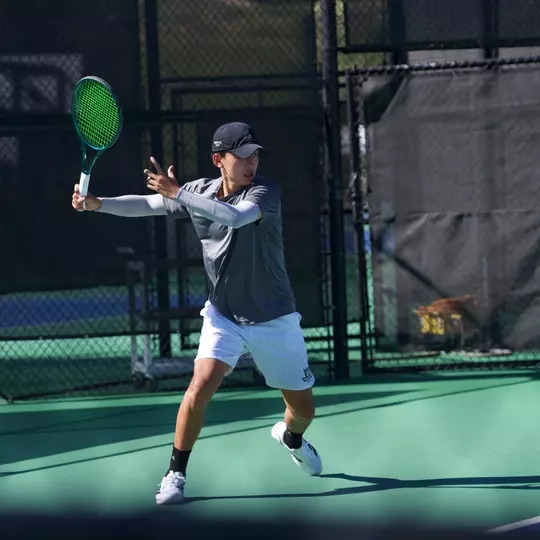 Ken Dinh returns a serve at the Bedford Cup