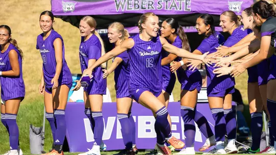 Wildcat soccer athletes high-fiving