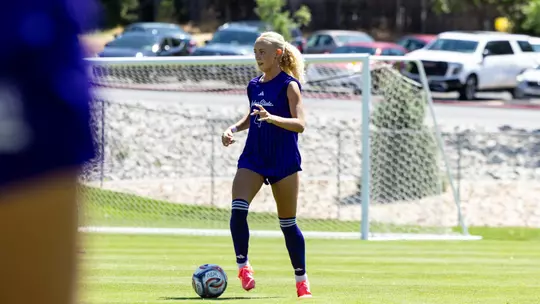 Wildcat soccer player dribbling ball