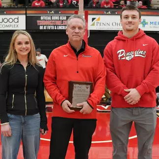 YSU cross country runner McKinley Fielding, Regional President for PNC Bank Ted Schmidt, and YSU football player Beau Brungard standing on a basketball court for the PNC Achievers Award.