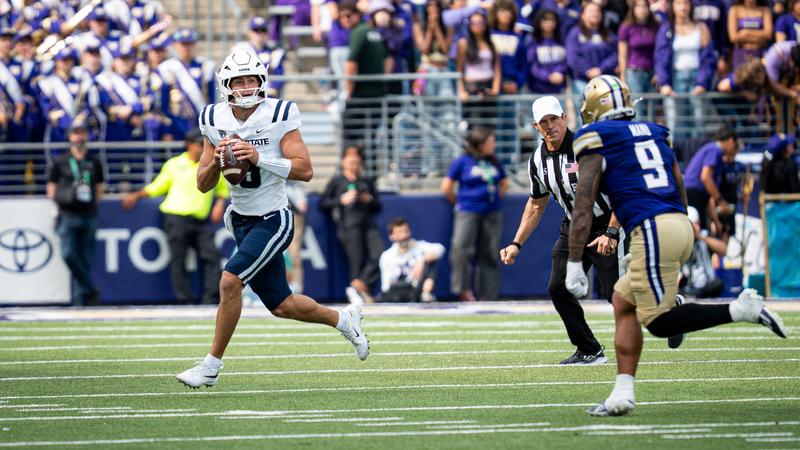 Utah State quarterback Grady Brosterhous rolls out and looks for an open receiver during the team's game at Washington