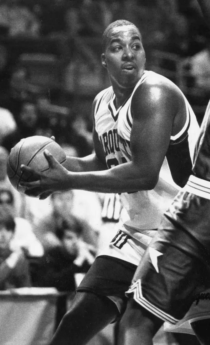 Marquette basketball player Damon Key looks to pass the ball while under tight defense, 1991-1994.