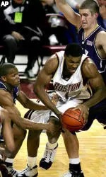 Craig Smith drives between Holy Cross guards John Hurley, right, and Torey Thomas during the first half.