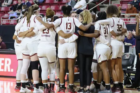 The women's basketball team huddles during a timeout