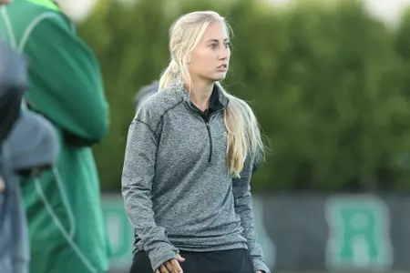 Taylor Schram, assistant coach, on the sideline of a soccer game.