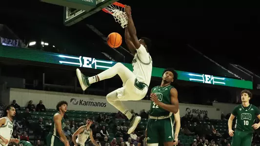 Godslove Nwabude holding the rim after dunking a basketball against Ohio, Jan. 3, 2026