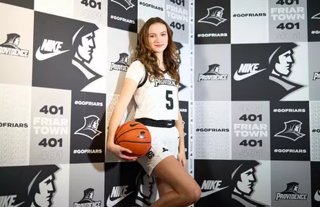 Sophi Hall poses at media day in front of the photo wall.