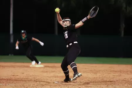 Riley Quirk pitching in softball game. 