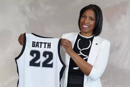 Erin Batth holds a commemorative jersey during a photoshoot to announce her hire as Providence College head Women's basketball coach