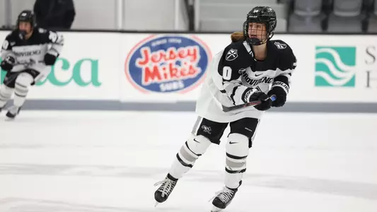 Women's ice hockey player Lauren Mack waiting for the puck during a game
