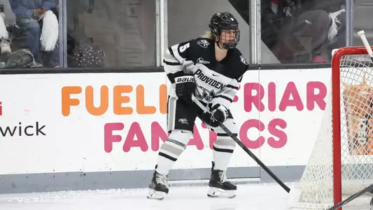 Women's ice hockey player Hannah Clarke with the puck behind her own net during a game