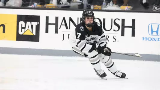 Women's ice hockey player Sarah Davies skating after the puck during a game