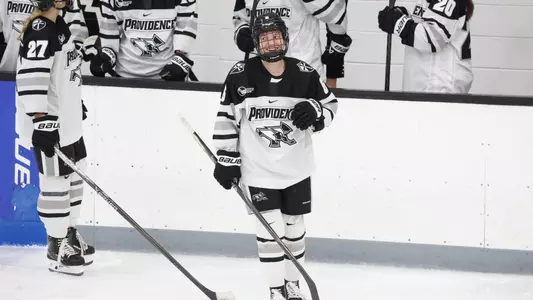 Women's ice hockey player Audrey Knapp smiling while skating on the ice during a media timeout