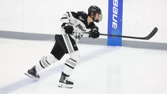 Women's ice hockey player Bella Paolucci taking a slap shot during a game