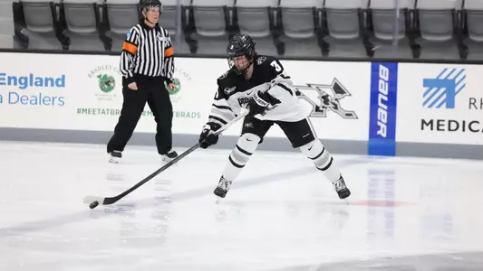 Women's ice hockey player Cali Cerruti skating with the puck during a game